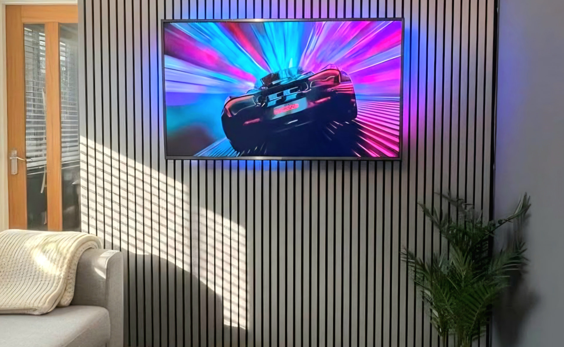 Wall-mounted TV with hidden cabling on an acoustic slat feature wall installed by TVI UK